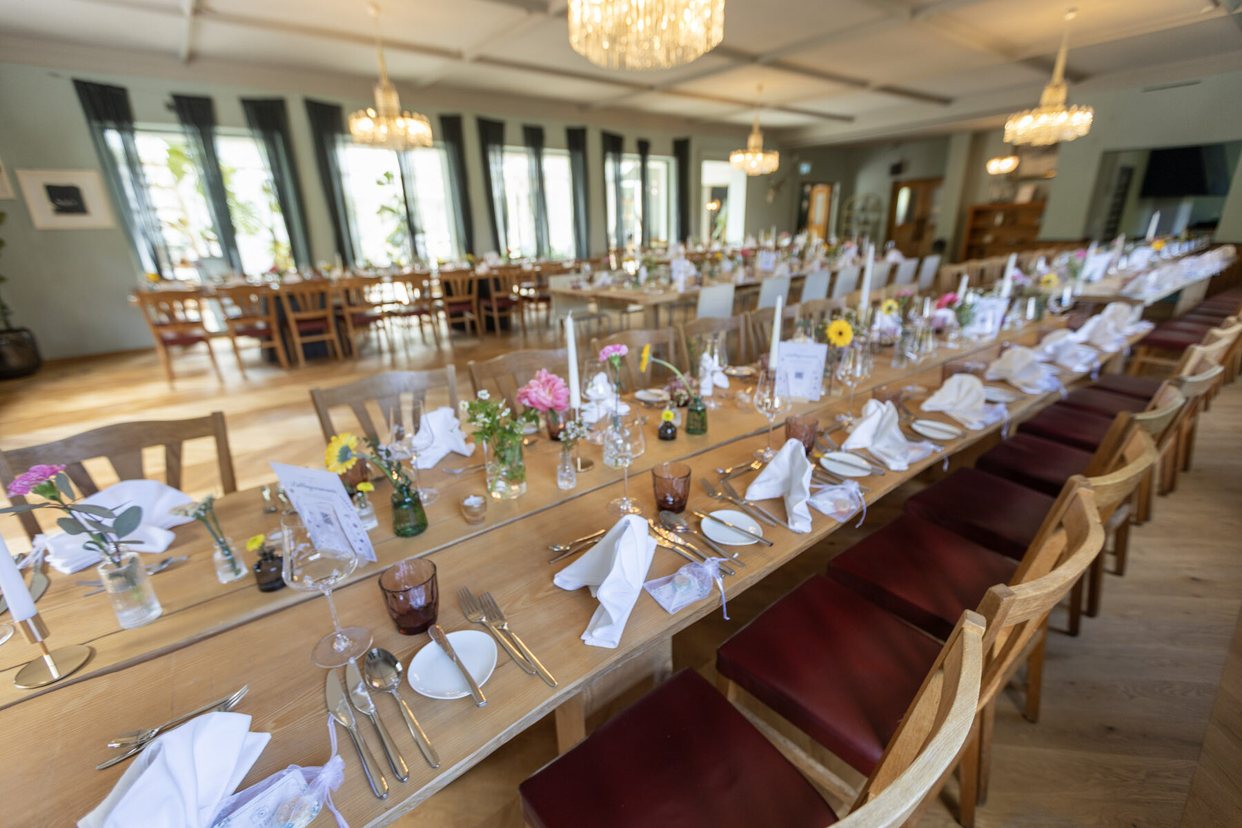 Der Ballsaal des Walliserhofs, hochzeitlich gedeckt: lange Tafel, Blumen, Kristallluster