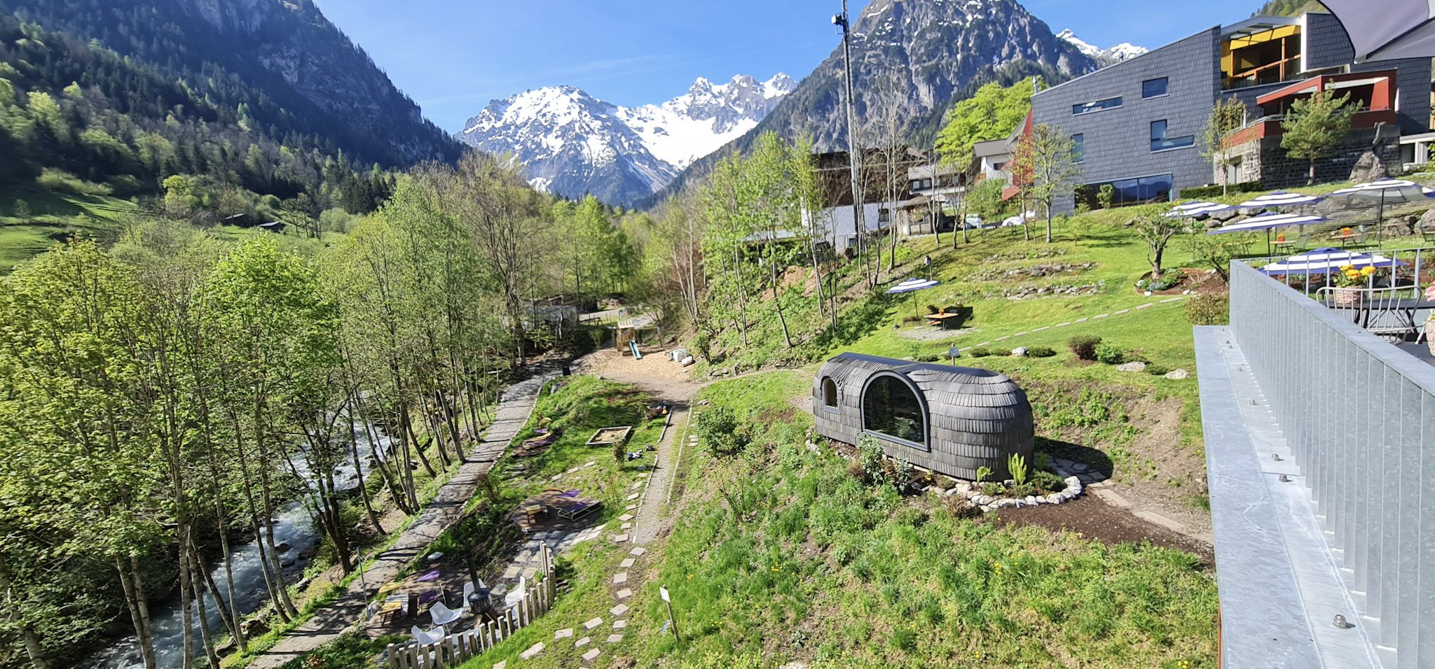 Der Walliserhof im Mai von der Strasse aus, dahinter die Berge des Brandnertals