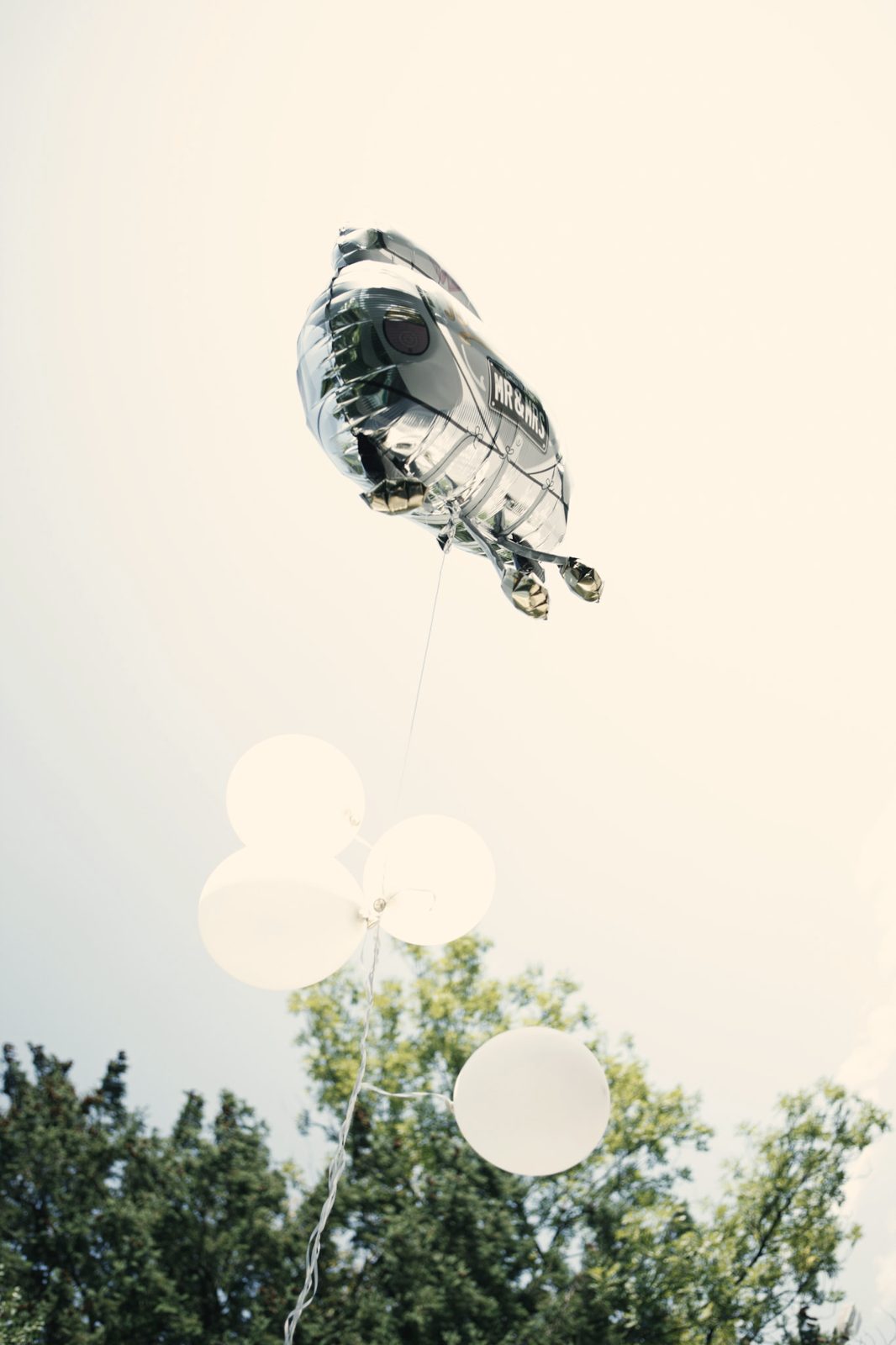 Ein Ballon steigt über den Bäumen auf.