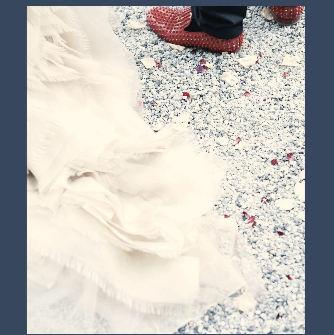 Der Saum des Kleides, rote Schuhe, Konfetti am Boden.